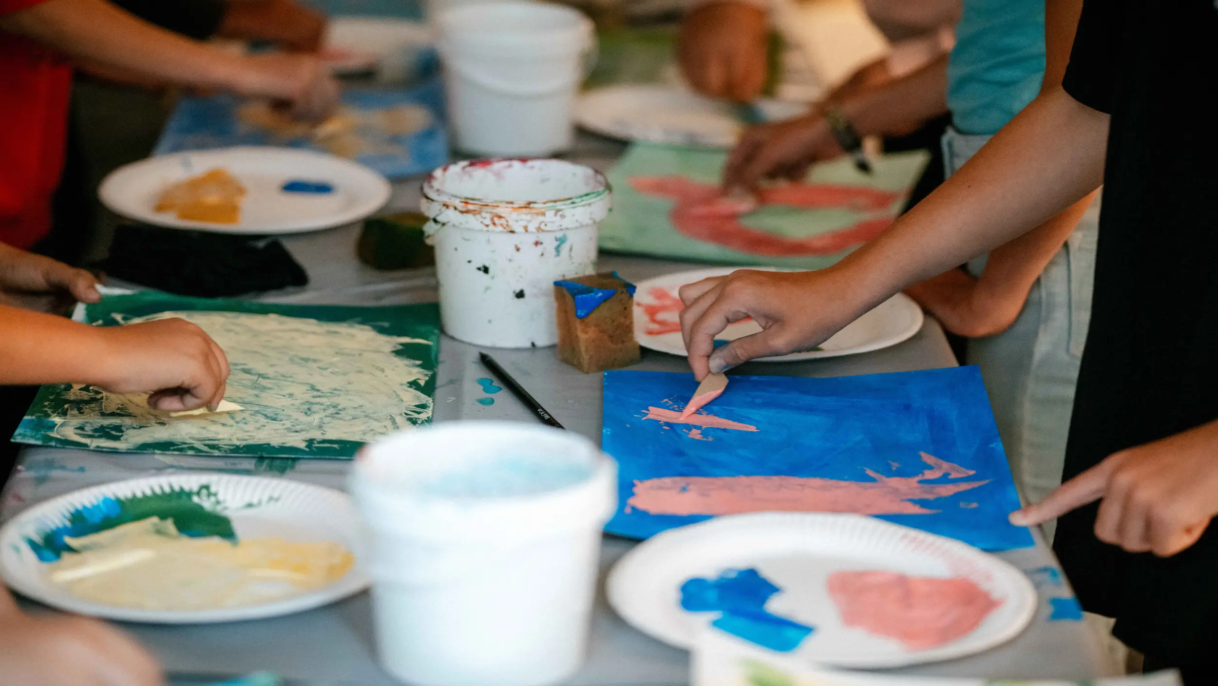 Schüler und Schülerinnen beim kreativen Experimentieren mit Farben 